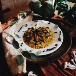 plated pumpkin risotto topped with vegetables and herbs