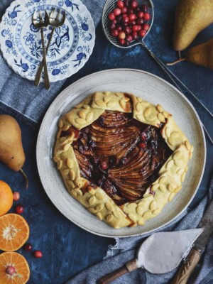 Baked vegan cranberry pear galette on a cake plate.