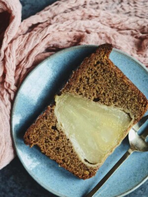 Slice of Vegan Chai Spice Pear Cake on a blue plate with a fork.