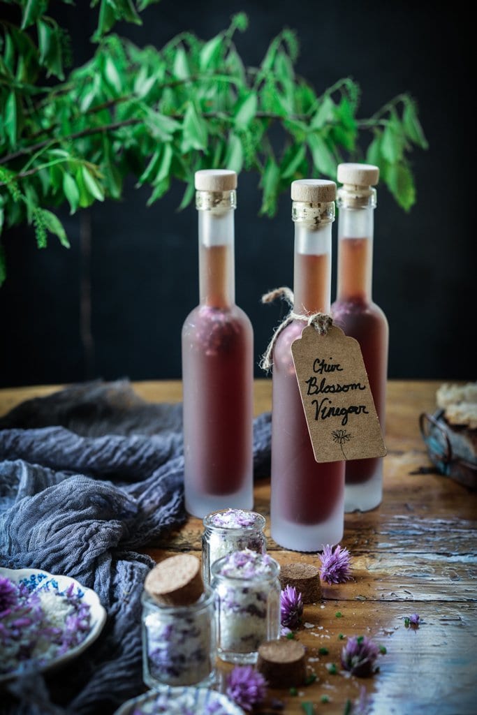 chive blossom vinegar in bottles on a table