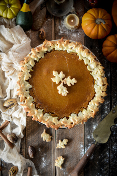 Easy vegan eggless pumpkin pie with maple leaf-shaped cutout crust in a pie plate.
