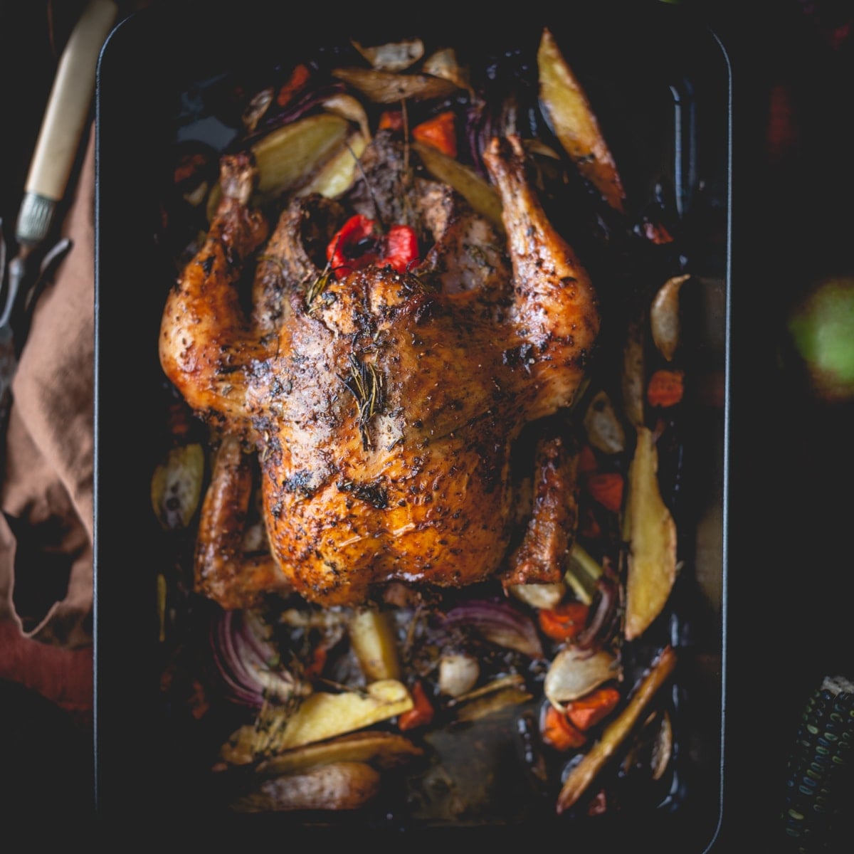 Sumac and herb roasted chicken with vegetables in a roasting pan.