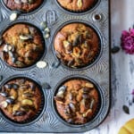 Vegan pumpkin muffins topped with pumpkin seeds in a muffin pan.
