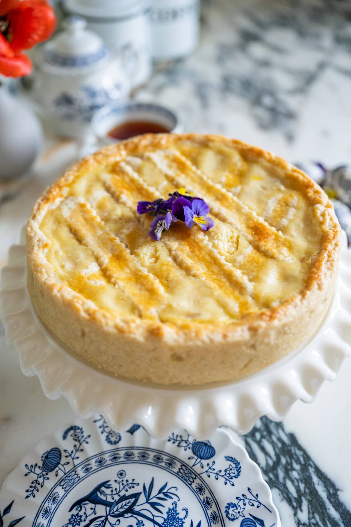 Whole Pastiera Napoletana with golden lattice top on a serving plate
